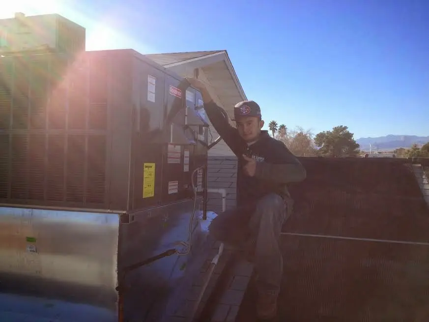 HVAC technician performing HVAC Inspection on a rooftop unit in Olyphant